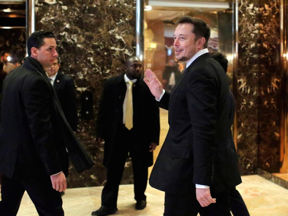Elon Musk walking waving trump tower