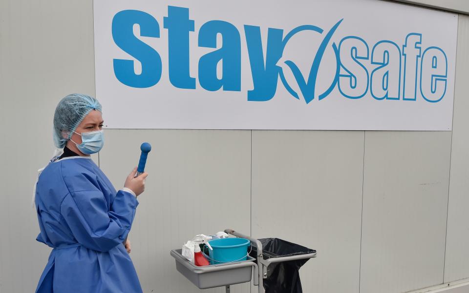 A nurse cleans outside a contenair at the Buissonets retirement home which has been converted into a visiting room for the relatives of patients infected with COVID-19, in Horion-Hozemont a section of the municipality of Grace-Hollogne, on April 29, 2020 - Belgium is in its seventh week of confinement in the ongoing corona virus crisis. The government has announced a phased plan to attempt an exit from the lockdown situation in the country, continuing to avoid the spread of Covid-19. (Photo by JOHN THYS / AFP) (Photo by JOHN THYS/AFP via Getty Images)