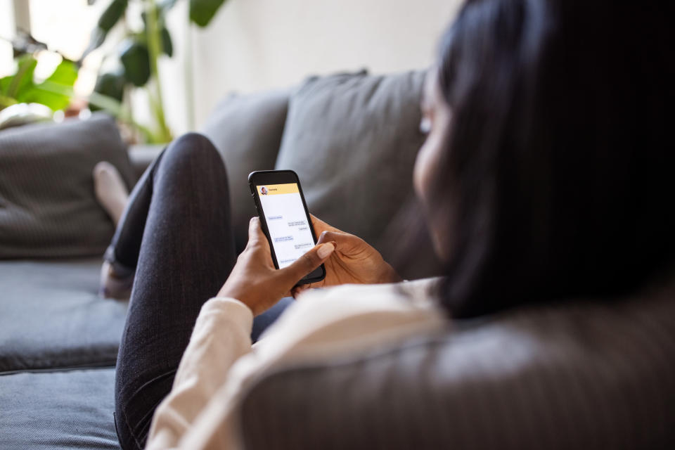 a person laying on the couch on their phone