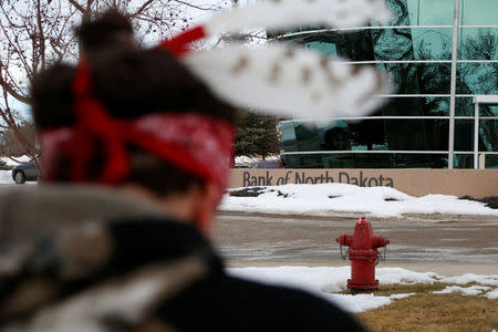 An opponent of the Dakota Access oil pipeline demonstrates outside the Bank of North Dakota in Bismarck, North Dakota, U.S., January 31, 2017. REUTERS/Terray Sylvester