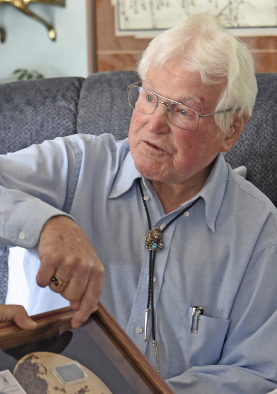 This July 30, 2019 photo shows Edwin Boger, 97, a veteran of World War II, showing his Army dog tag that was recently returned to him after being found in New Guinea nearly five years ago, in Bismarck, N.D. A stranger found Boger's dirty, rusted dog tag about five years ago while digging a hole for a school flagpole in Lemieng, Papua New Guinea. Kenneth Muo knew that only American soldiers wore dog tags and, armed with information on the tag including Boger's hometown and mother's name, he determined to return it to its rightful owner. (Tom Stromme/The Bismarck Tribune via AP)