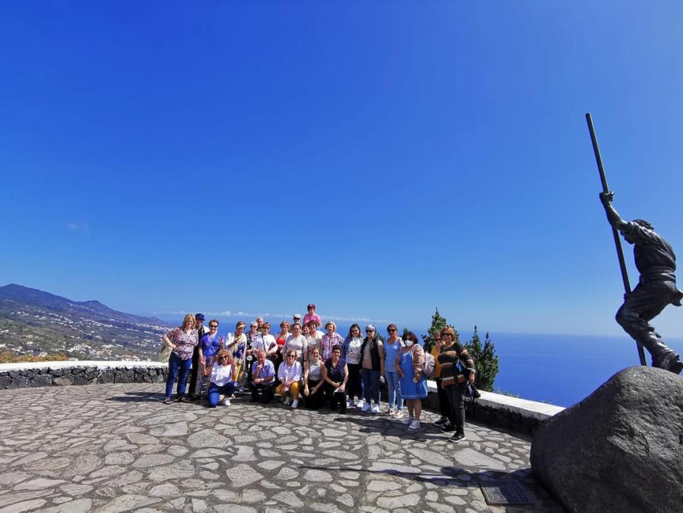 Un grupo de turistas se fotografían ante una de las impresionantes vistas que ofrece la isla de La Palma, tras sufrir a erupción volcánica hace unos meses); al fondo, otra isla canaria, Tenerife.
