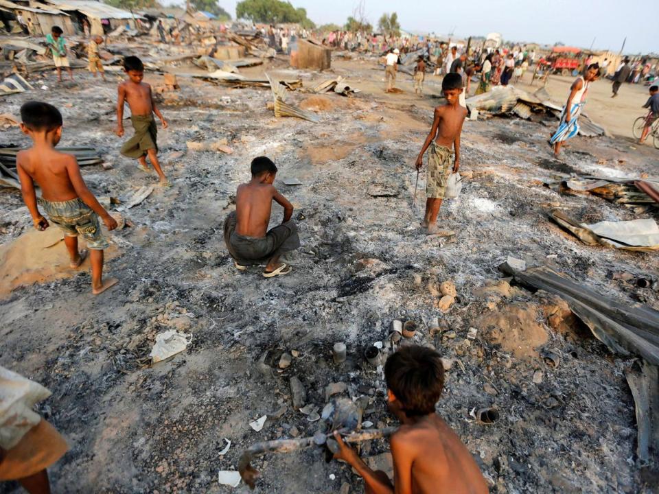 Boys search for rubbish amid the ashes of burnt houses at a camp for Rohingya Muslims in Rakhine State (Reuters)