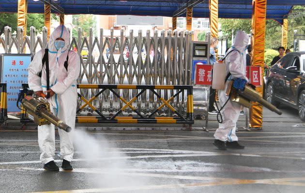 Volunteers wearing personal protective equipment spray disinfectant at an exam site ahead of China's national college entrance exam on June 5, 2022 in Bozhou, Anhui Province of China. (Photo by Zhang Yanlin/VCG via Getty Images) (Photo: VCG via Getty Images)