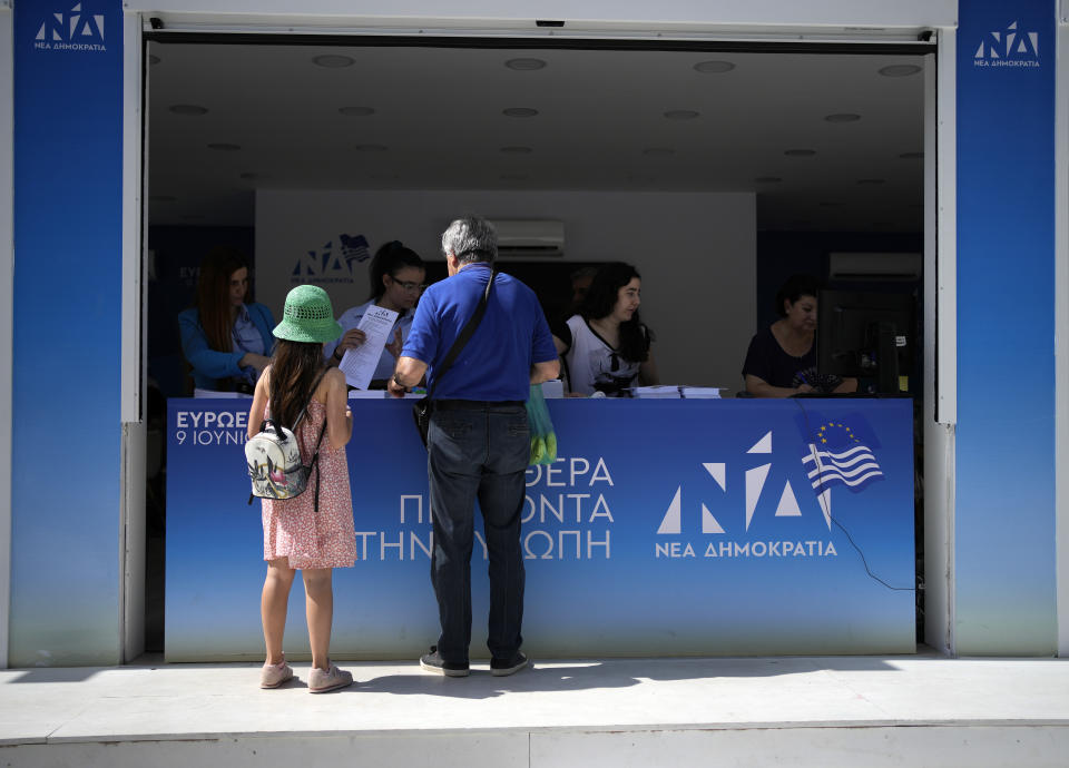 A man stands at an election kiosk of the ruling party of New Democracy in Athens, Greece, Friday, June 7, 2024. The European Election will take place on June 9. (AP Photo/Thanassis Stavrakis)