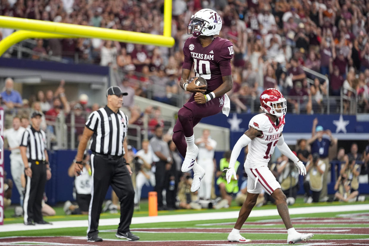 Texas A&M quarterback Marcel Reed (10) reacts in front of Arkansas defensive back Marquise Robinson (13) after scoring on a touchdown run during the first half of an NCAA college football game, Saturday, Sept. 28, 2024, in Arlington, Texas. (AP Photo/Julio Cortez)