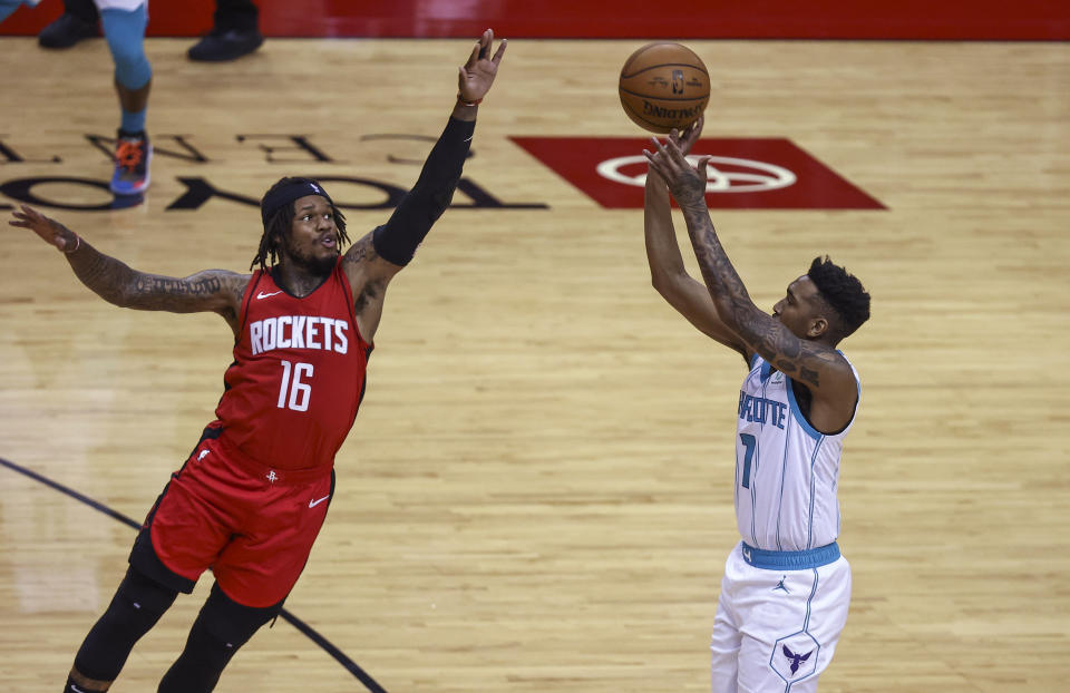 Charlotte Hornets guard Malik Monk (1) shoots as Houston Rockets guard Ben McLemore (16) defends during the second quarter of an NBA basketball game Wednesday, March 24, 2021, in Houston. (Troy Taormina/Pool Photo via AP)