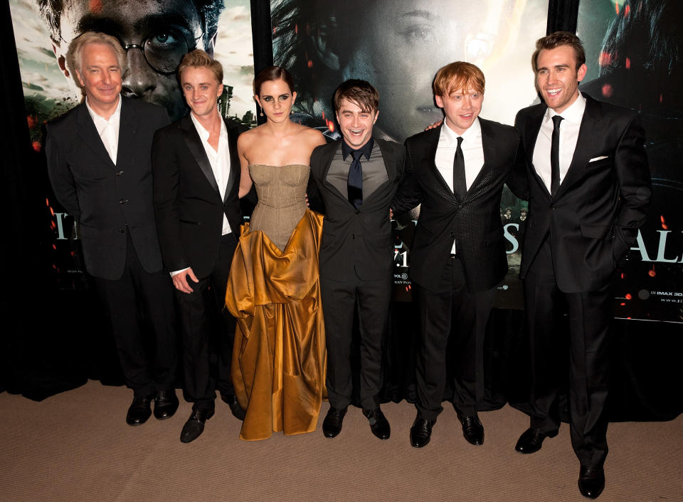 Five cast members from Harry Potter, three men in suits and a woman in a strapless gown, posing at a film event