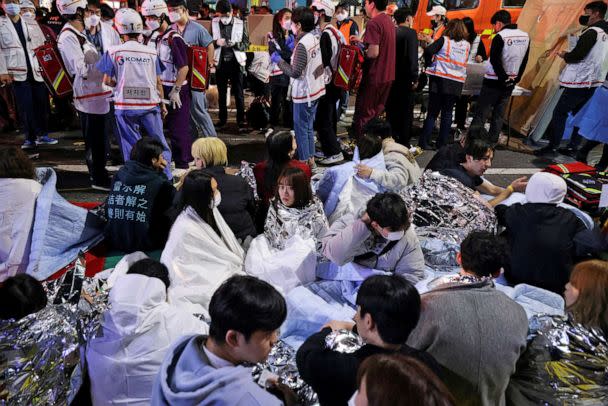 PHOTO: People sit on the street after being rescued, at the scene where dozens of people were injured in a stampede during a Halloween festival in Seoul,  South Korea, Oct. 30, 2022. (Kim Hong-ji/Reuters)