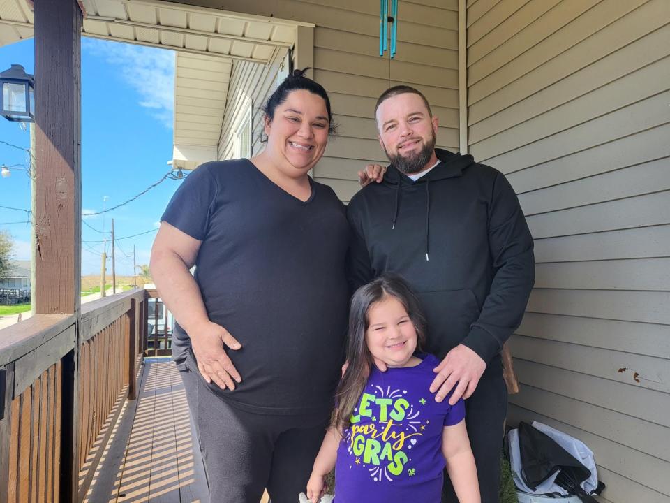 Amber Galliano, Teagan Theriot and Brett Theriot pose for a photo on their porch in Chauvin. The family intends to sell their home and move away because they say nothing is left in their community for their children, February 19.
