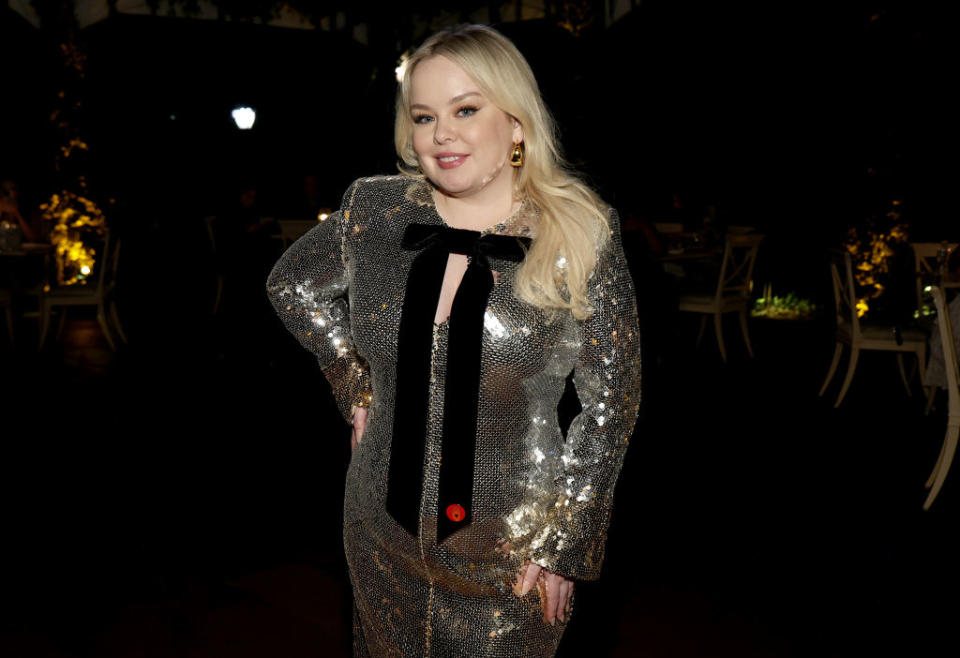 Nicola Coughlan posing in a sparkling dress with a black tie detail at an evening event