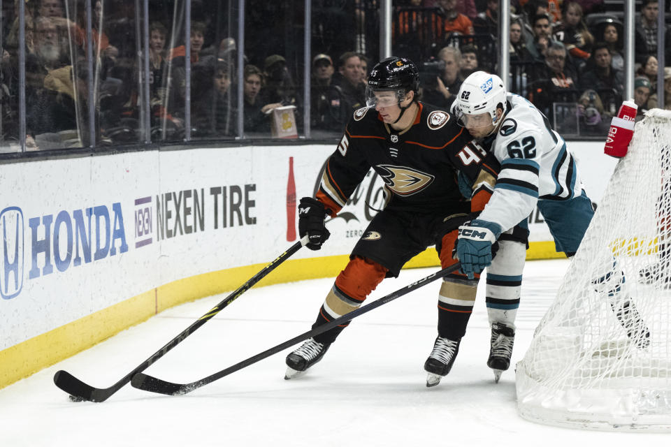 Anaheim Ducks defenseman Colton White (45) controls the puck away from San Jose Sharks right wing Kevin Labanc (62) during the first period of an NHL hockey game in Anaheim, Calif., Friday, Jan. 6, 2023. (AP Photo/Kyusung Gong)