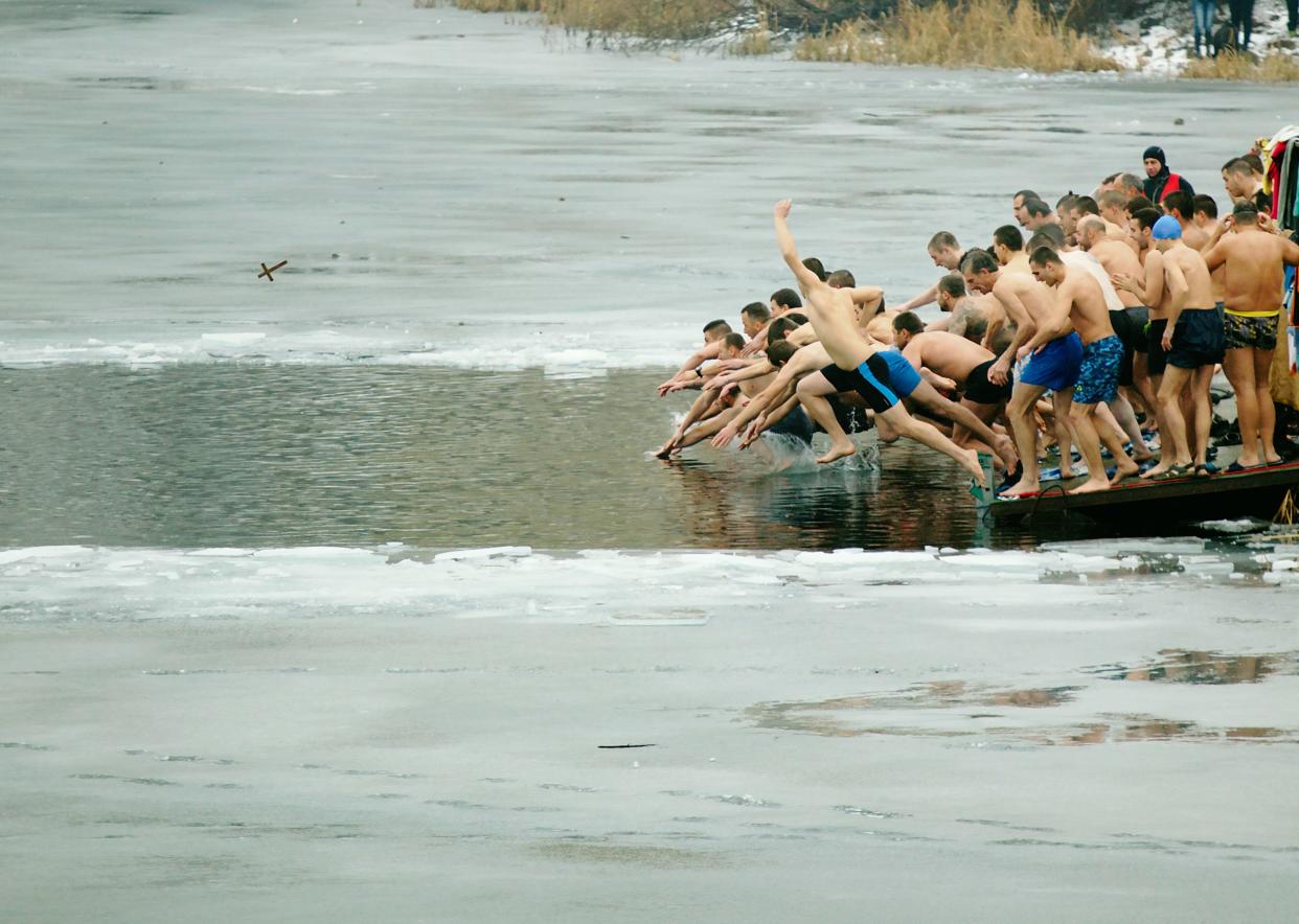 Sofia, Bulgaria - January 6, 2016: Many young men dive into the icy waters of Drujba lake to catch a holy cross  as part of Epiphany Day celebrations.