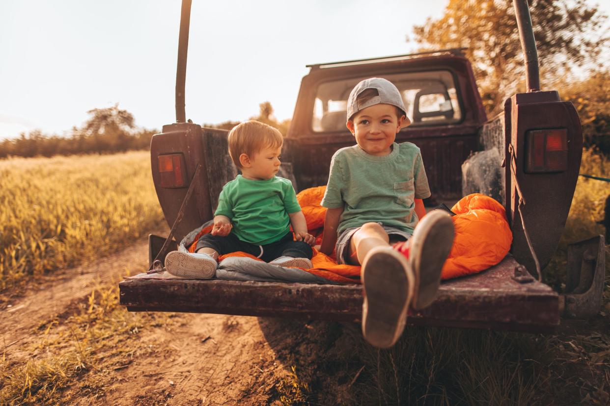 Photo of a two boys, brothers in their family pick-up truck getting ready for new family adventures