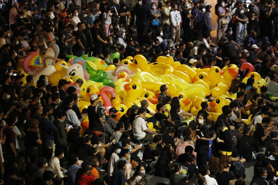 Inflatable yellow ducks, a common symbol of the protest movement, are floated through a crowd of anti-government protesters attending a rally Wednesday, Dec. 2, 2020 in Bangkok, Thailand. Thailand's highest court has acquitted Prime Minister Prayuth Chan-ocha of breaching ethics clauses in the country's constitution, allowing him to stay in his job. (AP Photo/Sakchai Lalit)
