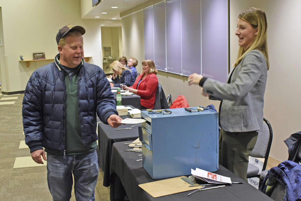 Casey Cashman, left, of Bismarck, places his ballot into a box as Bailey Doll watches at the North Dakota Republican Presidential caucus on the campus of Bismarck State College, Monday, March 4, 2024, in Bismarck, N.D. (Tom Stromme/The Bismarck Tribune via AP)