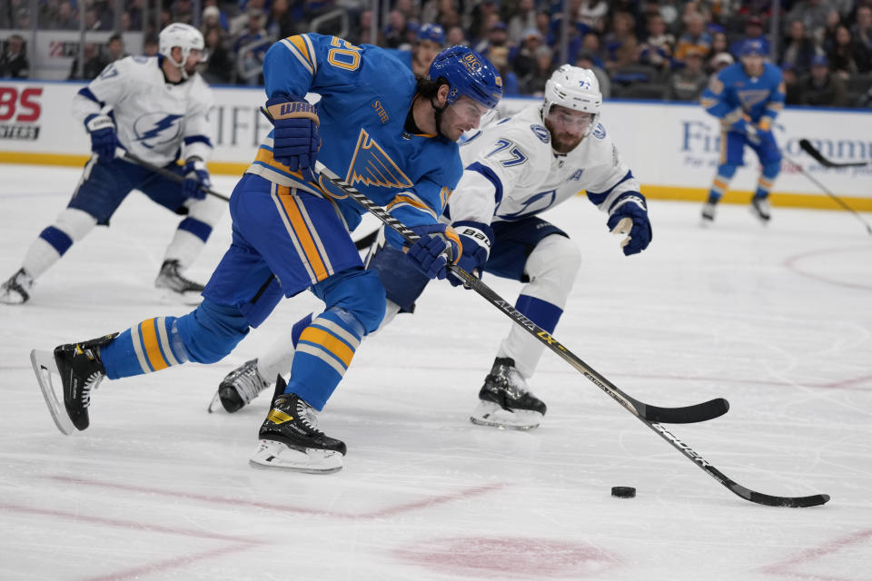 St. Louis Blues' Brandon Saad (20) brings the puck down the ice as Tampa Bay Lightning's Victor Hedman (77) defends during the second period of an NHL hockey game Saturday, Jan. 14, 2023, in St. Louis. (AP Photo/Jeff Roberson)