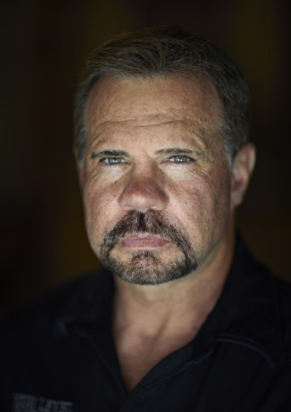 In this April 9, 2019, photo, Grant Whitus poses for a portrait at his home in Lake Havasu City, Ariz. Whitus' marriage fell apart a year after he led his SWAT team into Columbine High School's library, where he was the first to find the dead children's bodies. (AP Photo/John Locher)