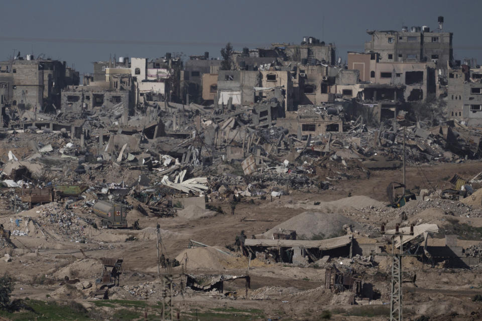 Israeli troops walk in the Gaza Strip as seen from southern Israel, Thursday, Dec. 21, 2023. The army is battling Palestinian militants across Gaza in the war ignited by Hamas' Oct. 7 attack into Israel. (AP Photo/Leo Correa)