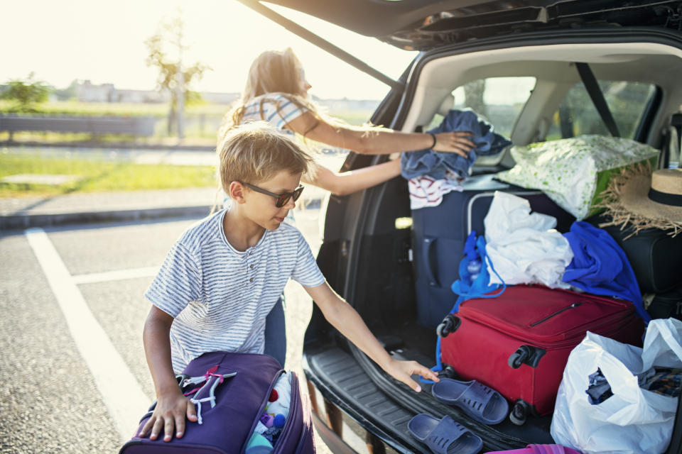 Kids helping to pack the family car for road trip. 
Sunny summer day in Italy.
Nikon D850