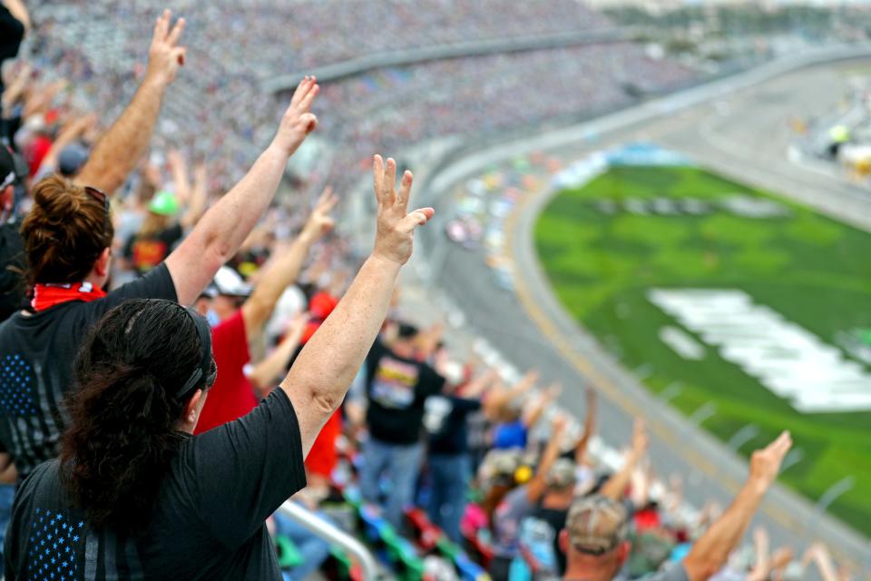 Fans hold up three fingers on the third lap of the Daytona 500 to honor Dale Earnhardt at the 2021 running of the Daytona 500 at Daytona International Speedway.