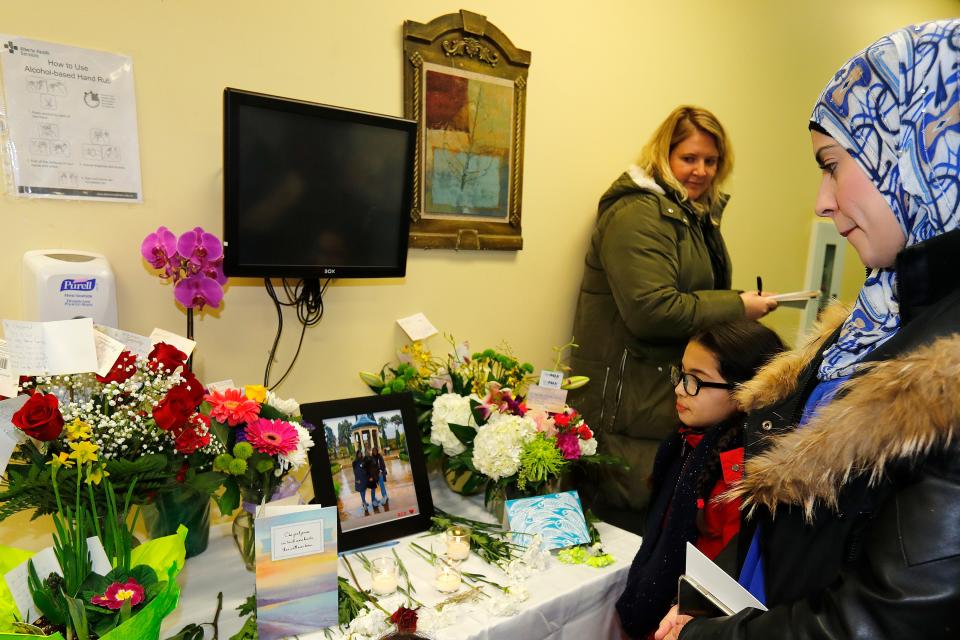 Khadija Sqalli, a patient of Dr. Shekoufeh Choupannejad, looks at a memorial at her office on Jan. 9, 2020 in Edmonton, Canada. Choupannejad, who along with her two daughters, Sara and Saba, were victims on the Ukraine International Airlines flight that crashed in Iran.