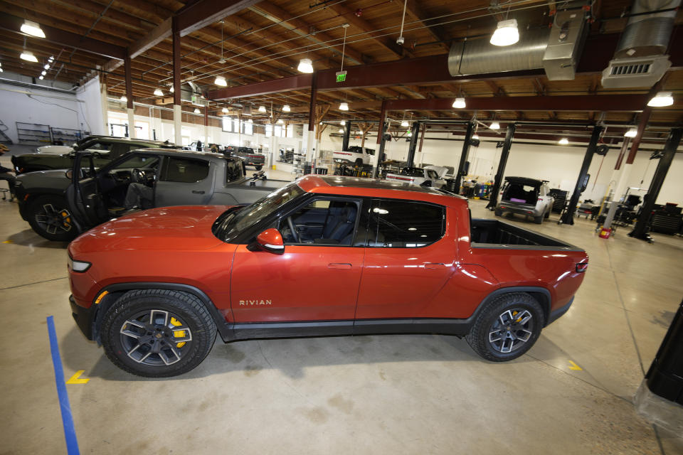 FILE - A 2023 R1T pickup truck is charged in a bay at a Rivian delivery and service center Feb. 8, 2023, in Denver. Shares of Rivian are soaring before the opening bell on Wednesday, June 26, 2024, after Volkswagen has agreed to invest up to $5 billion in a new joint venture with the electric vehicle maker.(AP Photo/David Zalubowski, File)