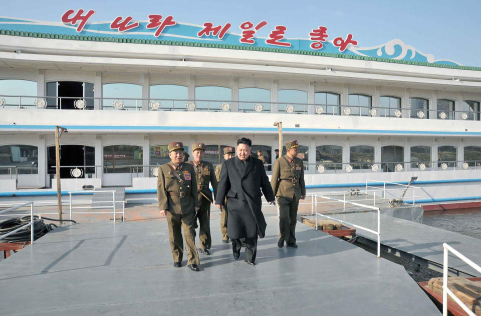 This undated photo released on March 25, 2013 North Korean leader Kim Jong-Un (C) inspecting a restaurant boat Taedonggang being laid down by the Korean People's Army at an undisclosed location in North Korea.