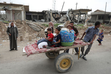 A displaced Iraqi family is transported on a cart as the battle between the Iraqi Counter Terrorism Service and Islamic State militants continues nearby, in western Mosul, Iraq, April 23, 2017. REUTERS/Marko Djurica