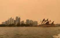 FILE PHOTO: The haze from bushfires obscures the sun setting above the Sydney Opera House in Sydney