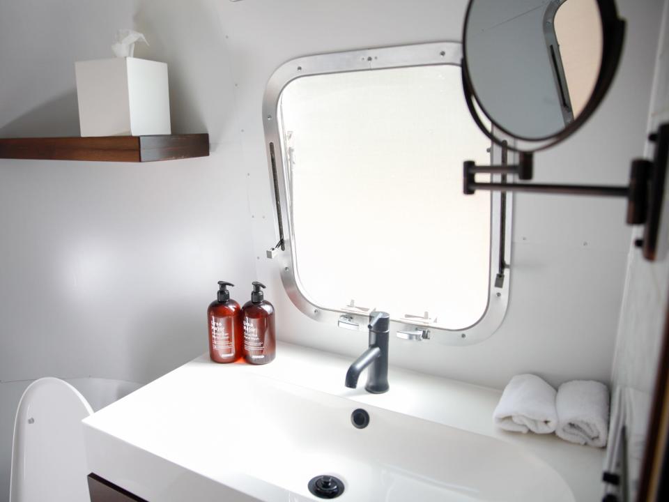 a sink with toiletries and windows