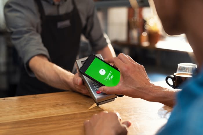 Customer making a contact-less payment with a smartphone.