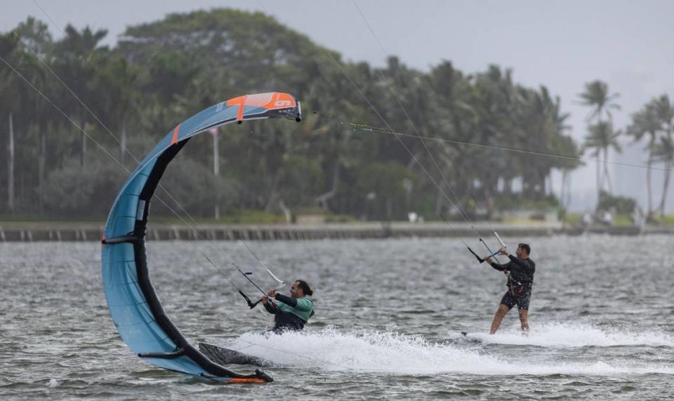 Kite boarders catch waves as rain makes its way over the area as seen from Matheson Hammock Park on Tuesday, April 11, 2023, in Coral Gables, Fla.