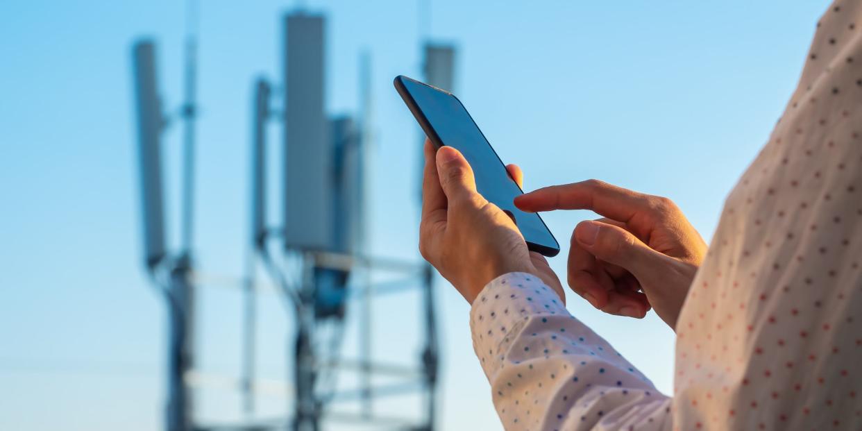holding phone in front of 5G cell tower