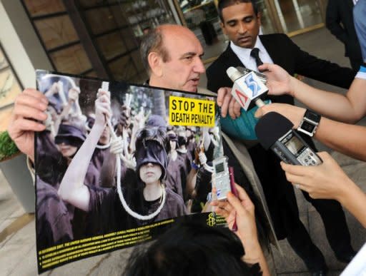 Alan Shadrake (L), a freelance journalist and author displays a campaign poster while talking to reporters outside of the Supreme court in Singapore. Singapore's highest court the defiant 76-year-old British author to serve six weeks in jail for contempt after he published a book denouncing judicial hangings in the city-state