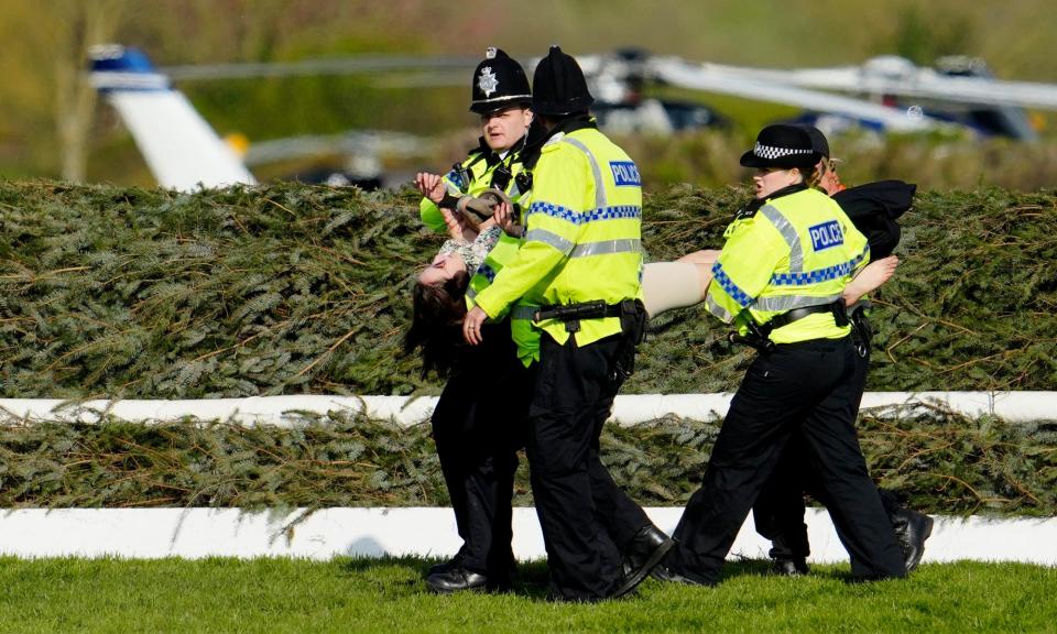 <span>Police remove an animal rights protester before the start of the 2023 Grand National at Aintree.</span><span>Photograph: Jon Super/AP</span>