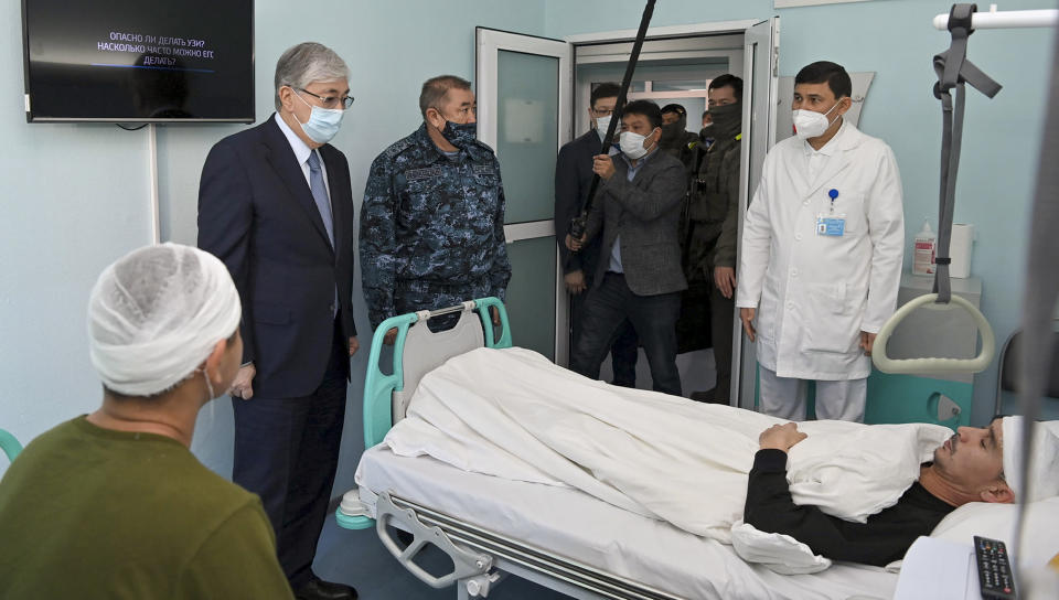 In this handout photo released by Kazakhstan's Presidential Press Service, Kazakhstan's President Kassym-Jomart Tokayev, second left, speaks to one of wounded during the unrest as he visited the Traumatology Department of the hospital in Almaty, Kazakhstan, Wednesday, Jan. 12, 2022. Kazakh authorities said Wednesday they detained 1,678 more people in the past 24 hours over their alleged participation in the violent unrest that rocked the former Soviet nation last week, the worst since Kazakhstan gained independence three decades ago. (Kazakhstan's Presidential Press Service via AP)