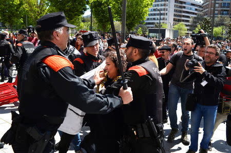 A protester breaks through a police line after a nine-year prison sentence was given to five men accused of the multiple rape of a woman during Pamplona's San Fermin festival in 2016, in Pamplona, Spain, April 26, 2018. REUTERS/Vincent West