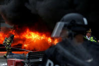 Police and firefighters stand near a limousine which was set ablaze during a protest against U.S. President Donald Trump on the sidelines of the inauguration in Washington, D.C., U.S., on January 20, 2017. REUTERS/Adrees Latif