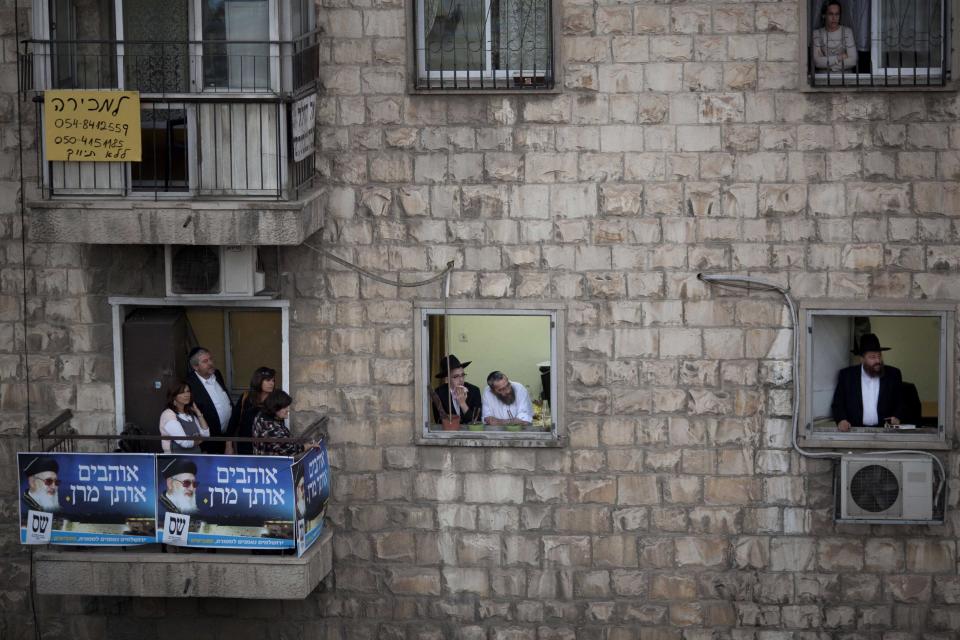 File - In this Oct. 13, 2013 file photo, ultra-Orthodox Jewish men and women watch from their balconies a ceremony a week after the funeral of the late religious spiritual leader of Israel's Sephardic Jews, Rabbi Ovadia Yosef, in Jerusalem. The Spanish conservative government, which enjoys an absolute majority in Parliament, plans to make amends in weeks to come with a law that offers citizenship to the legions of Jews forced to flee Spain in 1492. (AP Photo/Ariel Schalit, File)