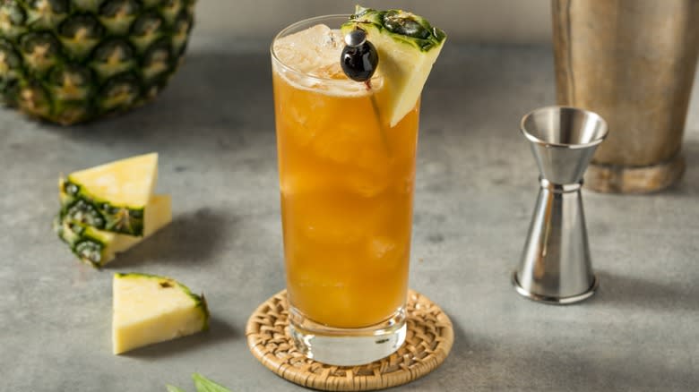 A Bahama Mama cocktail in a glass with pineapple wedges