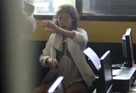 Heather Mack, the daughter of an American woman found dead inside a suitcase on the Indonesian holiday island of Bali, gestures while in custody in a police station in Denpasar August 14, 2014. REUTERS/Putu Setia