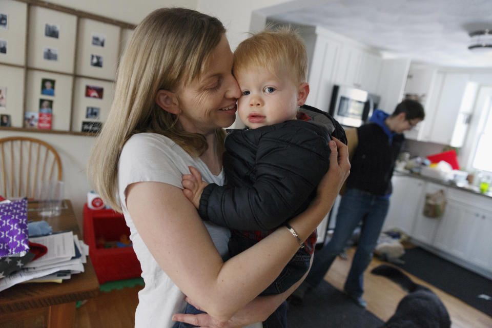 In this Friday, Nov. 16, 2018, photo, Anna Ford hugs her son Eli as he arrives home from nursery school with Ford's partner, Sara Watson, background, in the village of Saunderstown, in Narragansett, R.I. Three years after the landmark U.S. Supreme Court case that gave same-sex couples the right to marry nationwide, a patchwork of outdated state laws governing who can be a legal parent presents obstacles for many LGBTQ couples who start a family, lawyers say. (AP Photo/Michael Dwyer)
