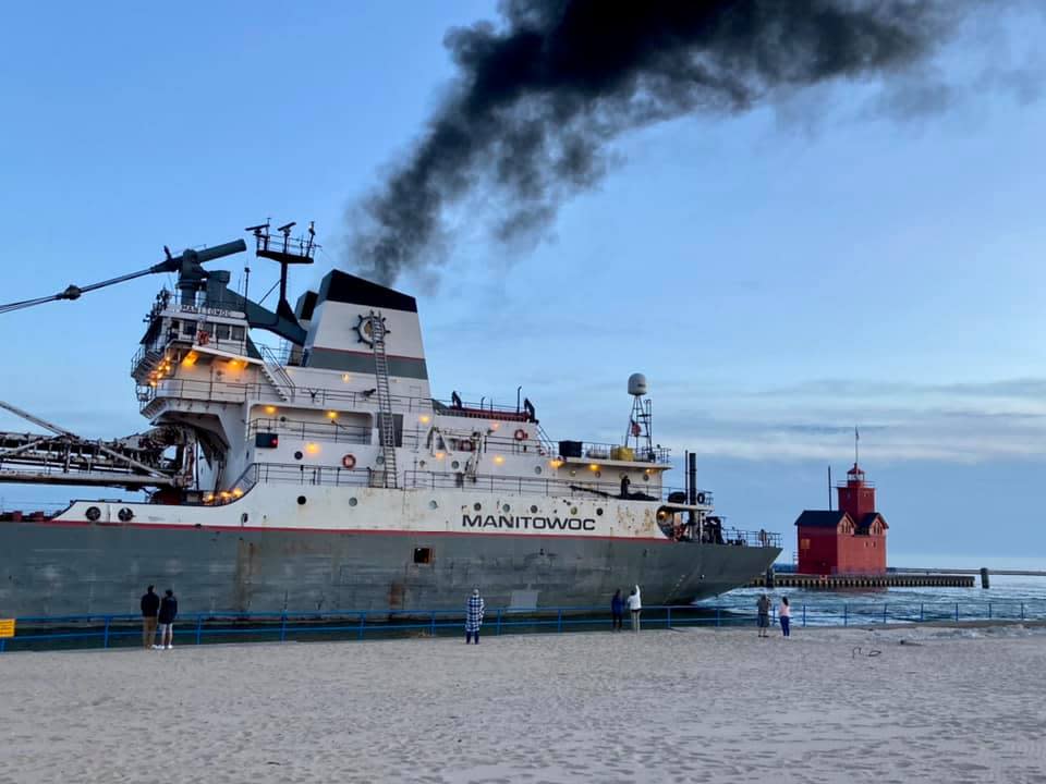 The Manitowoc, a nearly 600-foot cargo ship, navigates the Holland Harbor channel.