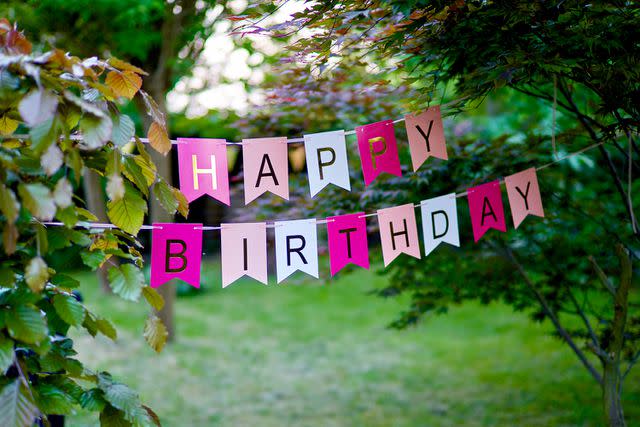 <p>Edwin Verhulst / 500px/Getty</p> Stock image of a birthday banner in a backyard