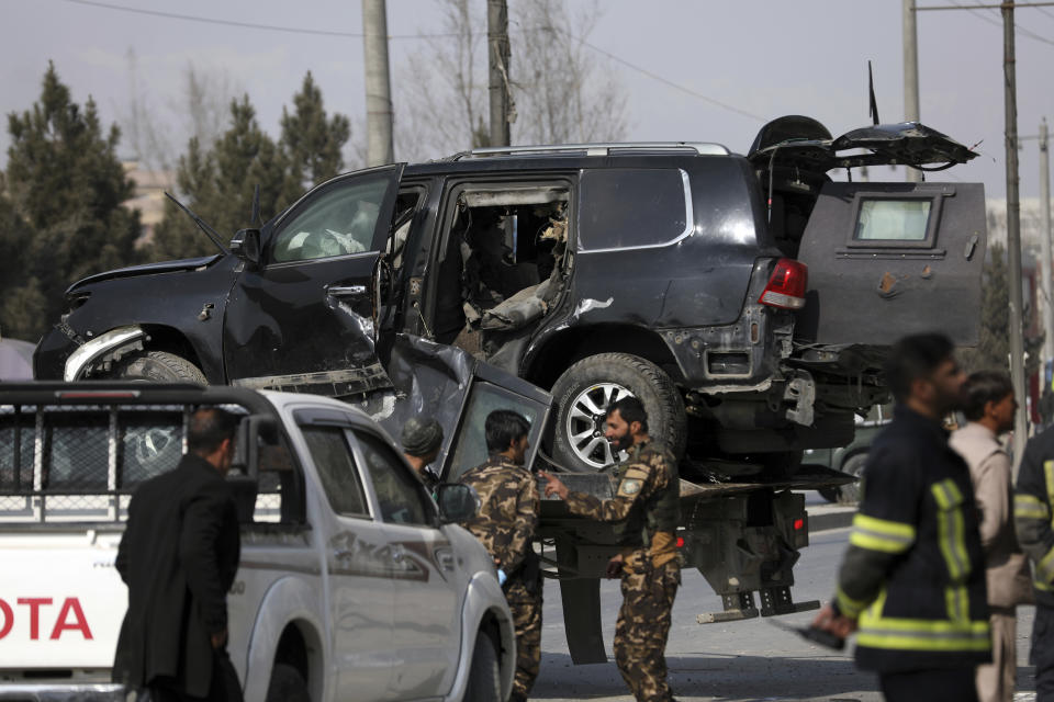 Afghan security personnel remove a damaged vehicle from the site of a deadly bomb attack in Kabul, Afghanistan, Tuesday, Feb. 9, 2021. A string of attacks on Tuesday in Afghanistan killed several government employees and several policemen. No one immediately claimed responsibility for the attacks. (AP Photo/Rahmat Gul)