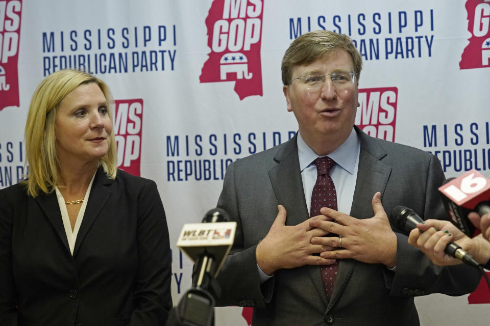 Mississippi Gov. Tate Reeves, speaks with reporters at the party headquarters, with his wife Elee Reeves at his side, after filing his qualifying papers to run for reelection, Tuesday, Jan. 3, 2023, in Jackson, Miss. . (AP Photo/Rogelio V. Solis)