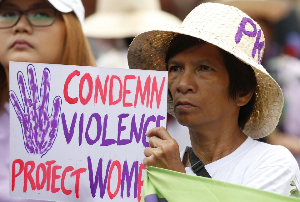 FILE - In this March 8, 2018, file photo, a protester displays a placard during a rally to mark International Women's Day which largely turns out to be an anti-government event in Manila, Philippines. The Philippine president signed Tuesday, July 16, 2019 a bill into law penalizing a range of acts of sexual harassment including catcalling, wolf-whistling and persistent telling of sexual jokes, which pro-women's groups have accused him of committing. (AP Photo/Bullit Marquez, File)