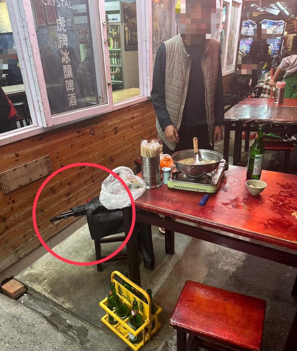 李姓男子至熱炒店外座位用餐，將該鎮暴槍放置於座椅上且明顯露出槍頭之畫面。（圖/記者 張泓笙翻攝）