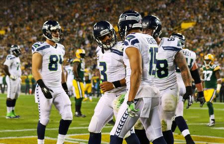 Seattle Seahawks quarterback Russell Wilson (3) celebrates his touchdown pass with teammates during the second half against the Green Bay Packers at Lambeau Field. Sep 20, 2015; Green Bay, WI, USA. Ray Carlin-USA TODAY Sports